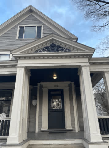 A house with a black front door and a window above it.