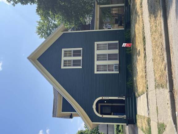 A black house with a white window and a door.