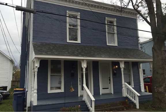 A blue house with white trim and a porch.