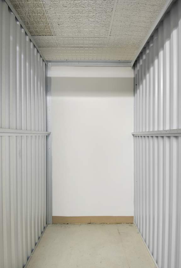 A long hallway with white walls and a white ceiling.