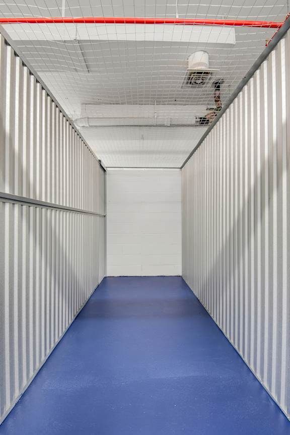 A long hallway with a blue floor and white walls.