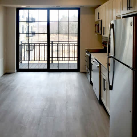 A kitchen with a refrigerator, oven, and sink.