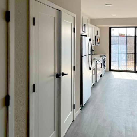 A kitchen with white cabinets and a white fridge.