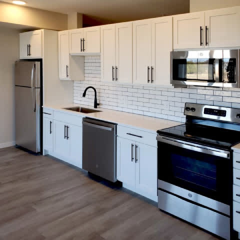 A kitchen with white cabinets and stainless steel appliances.