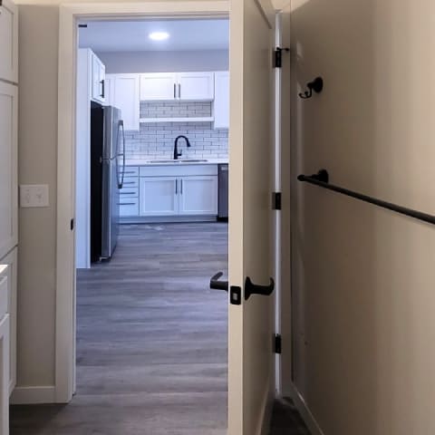 A kitchen with a refrigerator, sink, and cabinets.