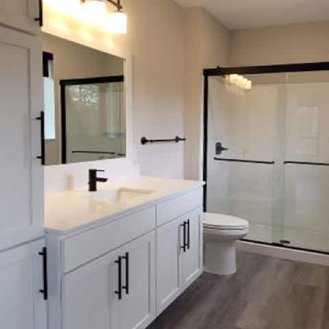 A white bathroom with a glass shower door.