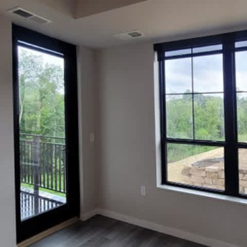 A room with a view of a backyard through the window.