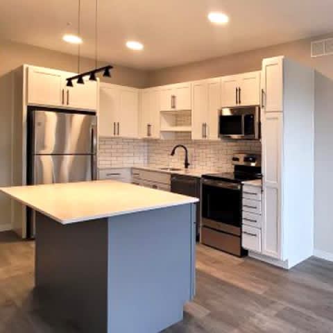 A kitchen with a white island in the middle of it.