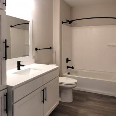 A white bathroom with a toilet, sink, and bathtub.