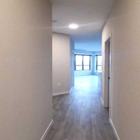 A long, narrow hallway with a door at the end.