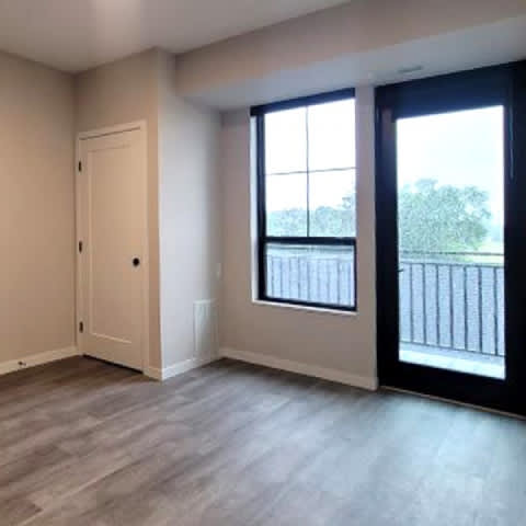 A room with a door, a window, and a balcony.