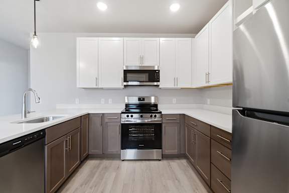 A modern kitchen with stainless steel appliances and wooden cabinets.