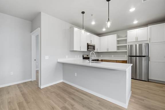 A kitchen with white cabinets and a wooden countertop.