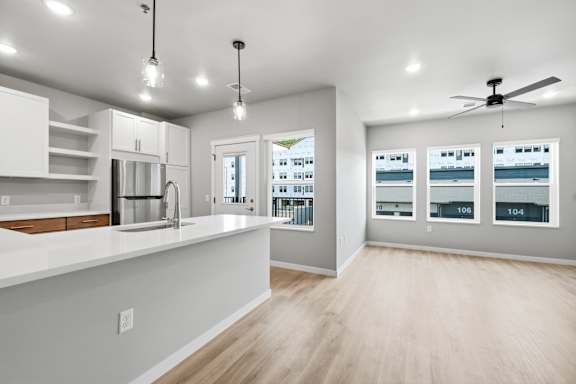 A kitchen with white cabinets and a white countertop.