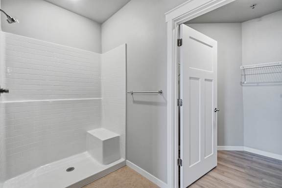 A white bathroom with a walk in shower and a white door.