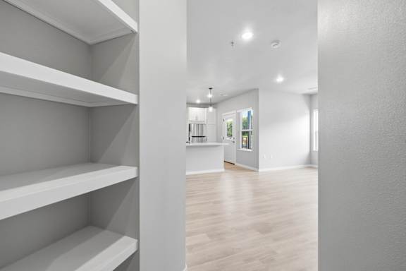 A room with white shelves and a wooden floor.