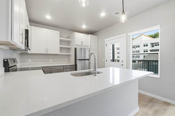 A modern kitchen with white cabinets and a large island.
