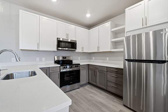 A modern kitchen with stainless steel appliances and white cabinets.