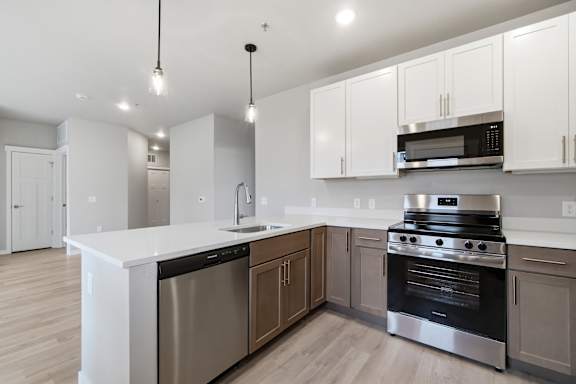 A modern kitchen with stainless steel appliances and white cabinets.
