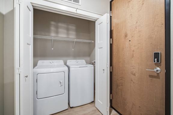 A small laundry room with a washer and dryer in it.