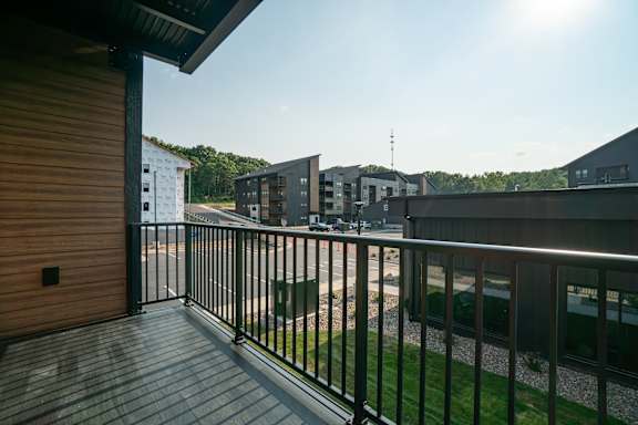 A balcony with a metal railing and a wooden floor.