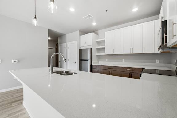 A modern kitchen with white cabinets and a large island.