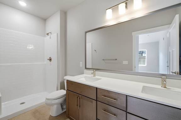 A bathroom with a white countertop and a white toilet.