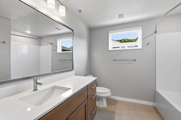 A bathroom with a white sink, toilet, and bathtub.