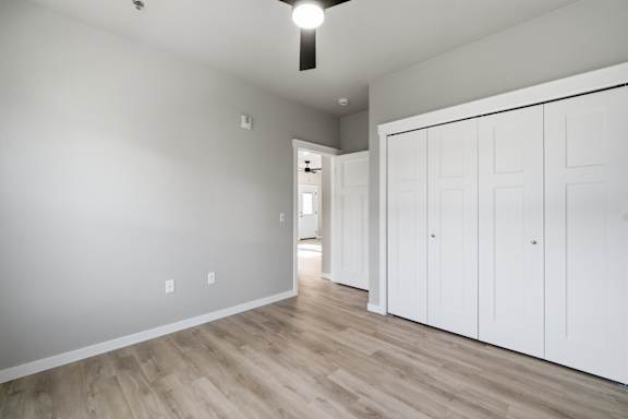 A room with white cupboards and wooden flooring.