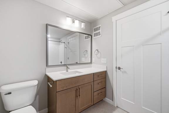 A white toilet sits next to a sink in a bathroom.