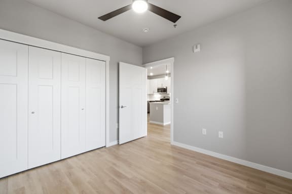 A room with a ceiling fan and wooden flooring.