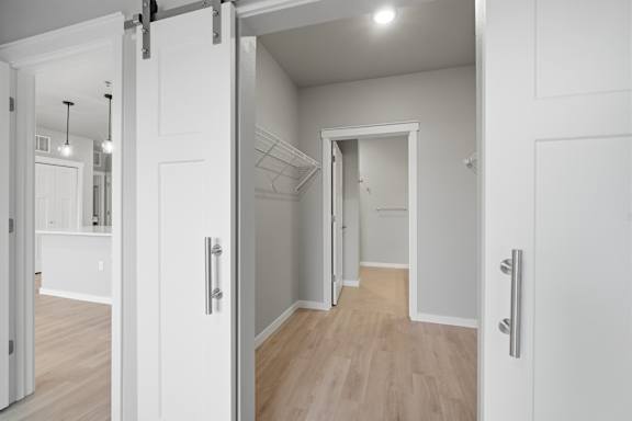 A white interior with a wooden floor and a white door.