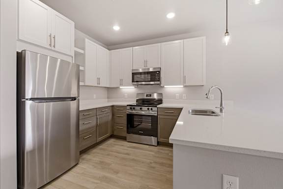 A modern kitchen with stainless steel appliances and white cabinets.