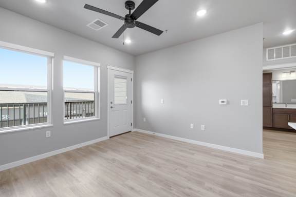 A room with a ceiling fan and lighting fixtures.