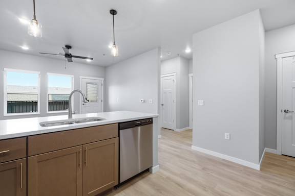 A kitchen with wooden cabinets and a stainless steel dishwasher.