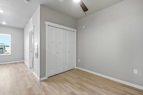 A room with a white door and wooden flooring.