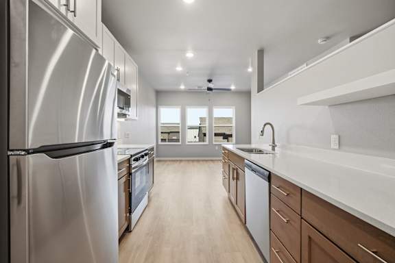 A modern kitchen with stainless steel appliances and wooden floors.