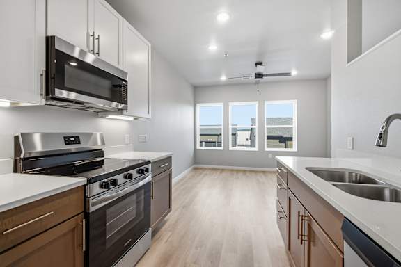 A modern kitchen with dark wood cabinets and stainless steel appliances.