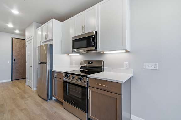A kitchen with white cabinets and stainless steel appliances.