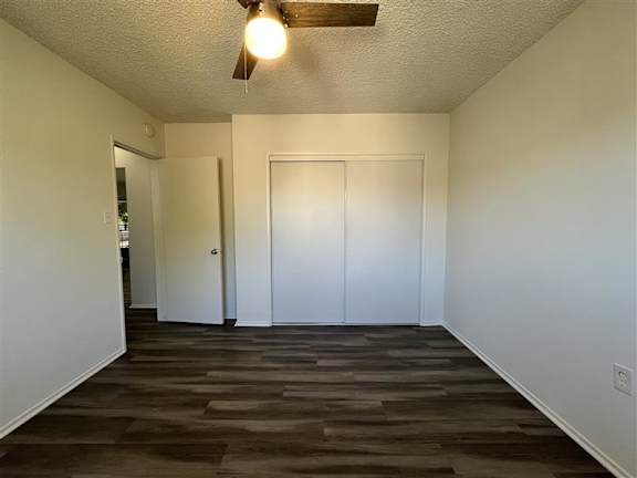 A room with a ceiling fan and two doors.