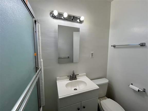A bathroom with a sink, mirror, and toilet.