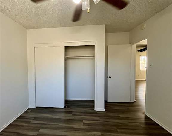 A room with a white door and a ceiling fan.