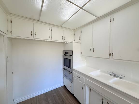 A kitchen with white cabinets and appliances.