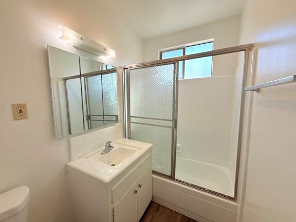 A white bathroom with a sink, mirror, and shower.