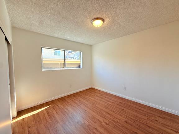 A room with a window and wooden flooring.