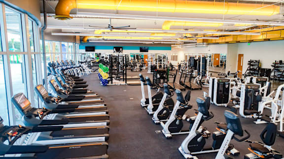 A gym with treadmills, weights, and exercise equipment.