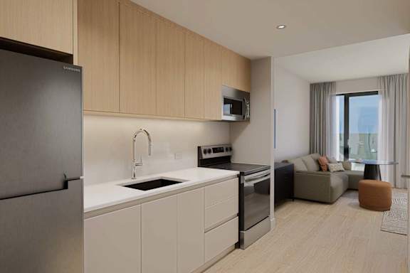 A modern kitchen with a refrigerator, sink, oven, and microwave.