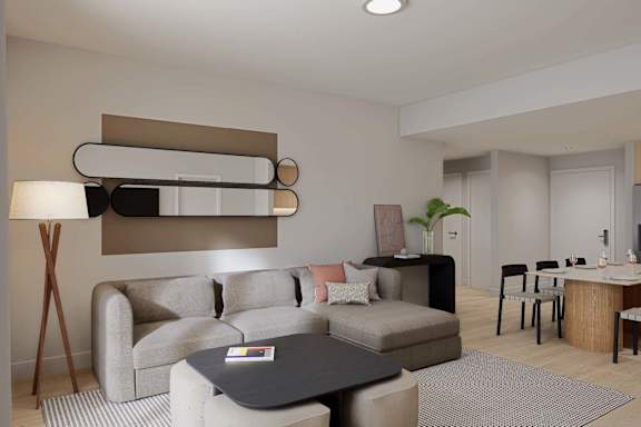 A modern living room with a grey sofa, a black coffee table, and a wooden floor lamp.
