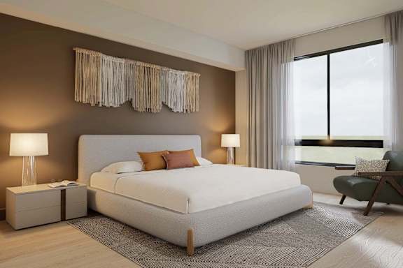A bedroom with a large bed and a window with curtains.