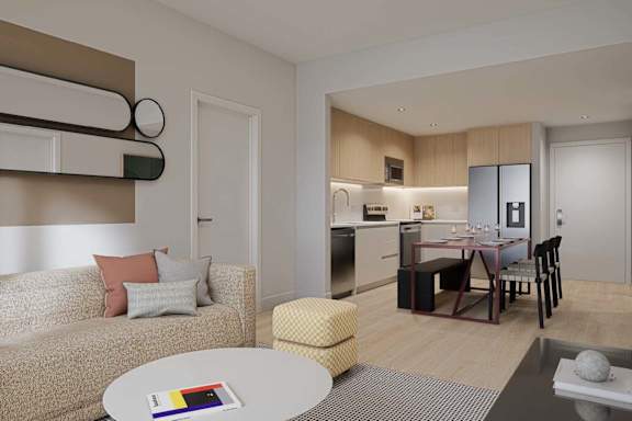 A modern living room with a beige sofa and a round table.